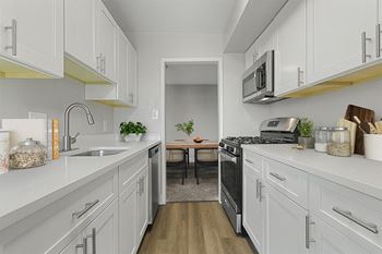 A kitchen with white cabinets and stainless steel appliances
